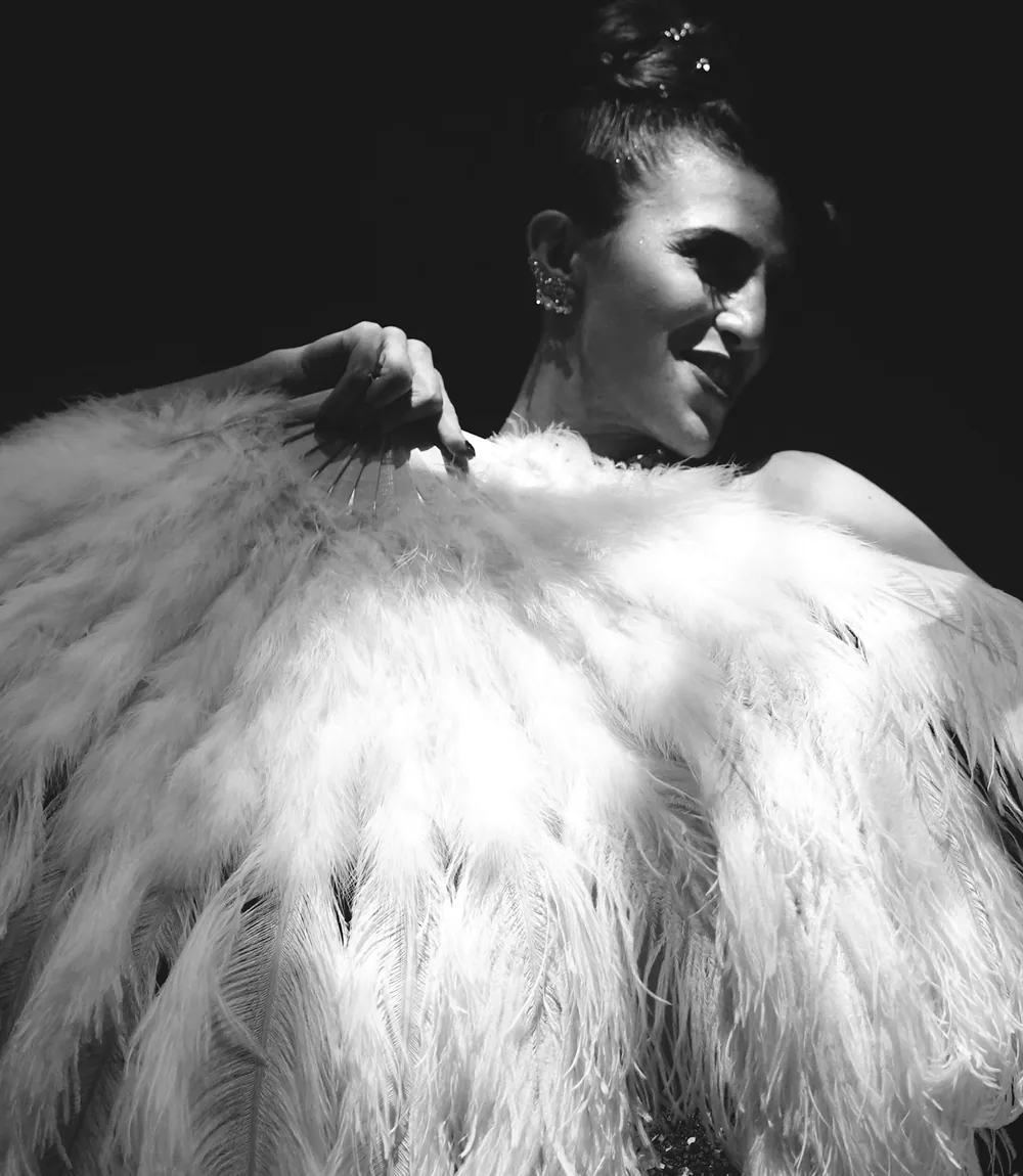 Artystka kabaretowa w misternym nakryciu głowy z piór w stylu showgirl